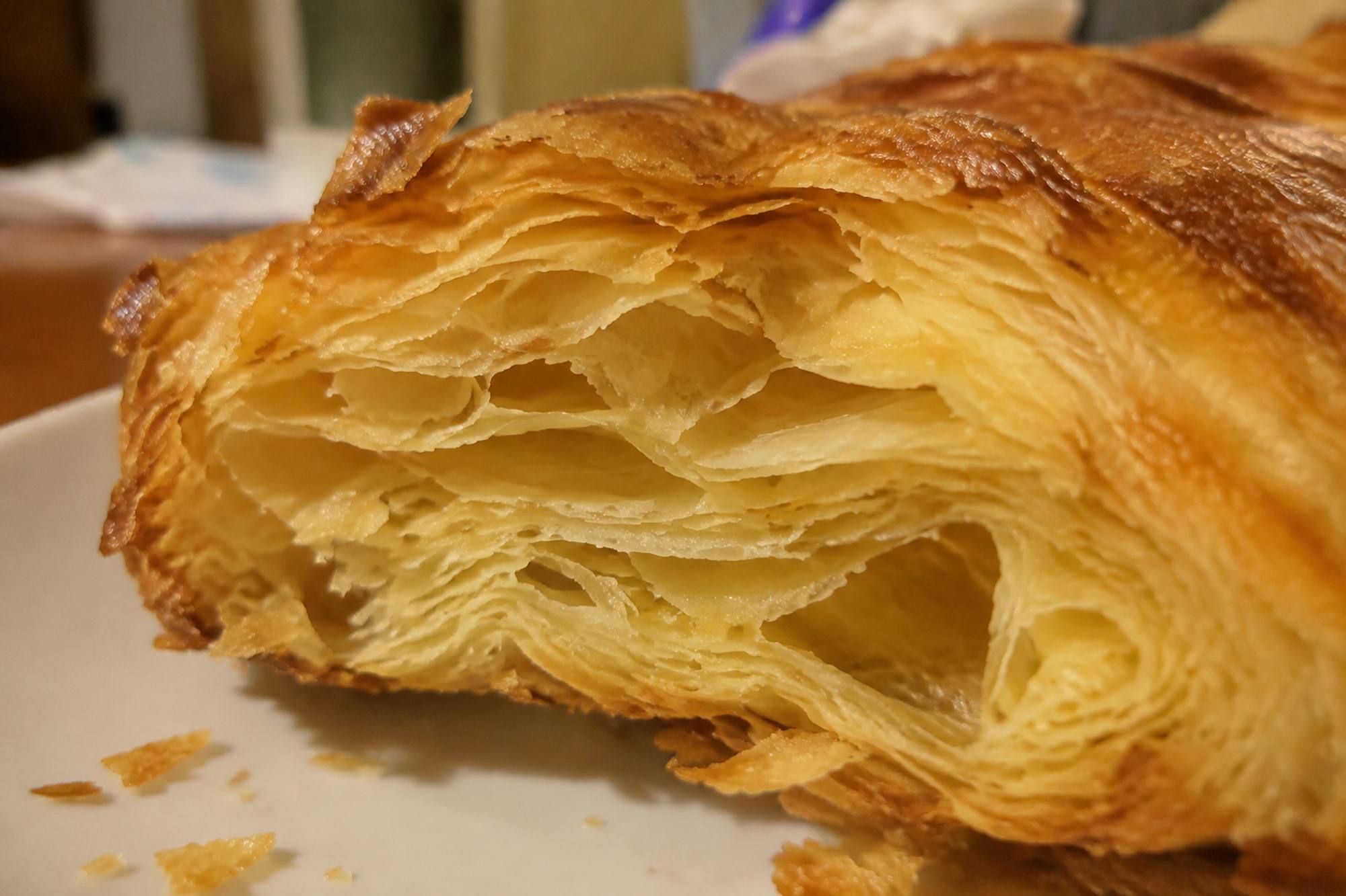 Close-up of the cut edge of baked puff pastry showing many thin golden layers
